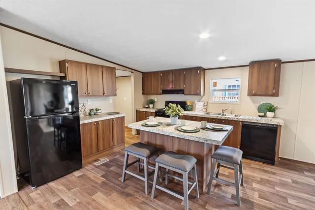 a kitchen with a refrigerator a table and chairs in it