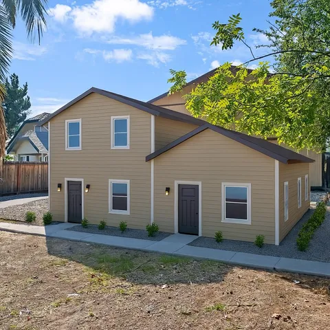 an empty room with wooden floor a ceiling fan and windows