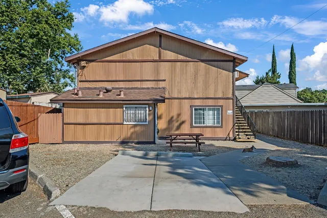 a view of an empty room with wooden floor and a ceiling fan