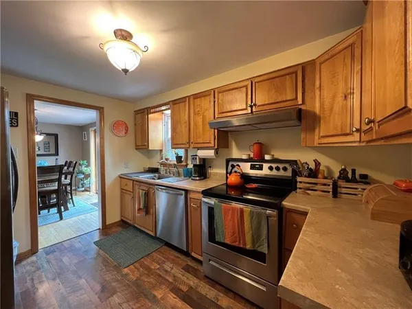 a kitchen with stainless steel appliances granite countertop a stove a sink and a microwave
