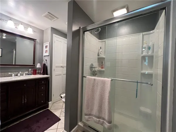 a bathroom with a double vanity sink a toilet and shower