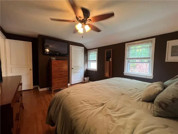a bedroom with a bed and a ceiling fan