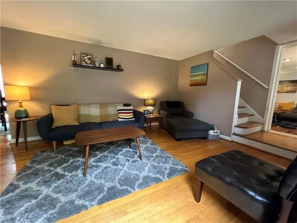 a living room with furniture rug and wooden floor