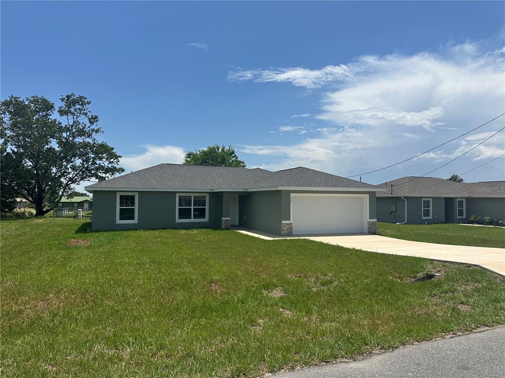 a front view of house with yard and trees