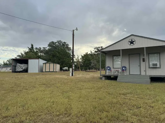 a view of a house with a patio and a yard