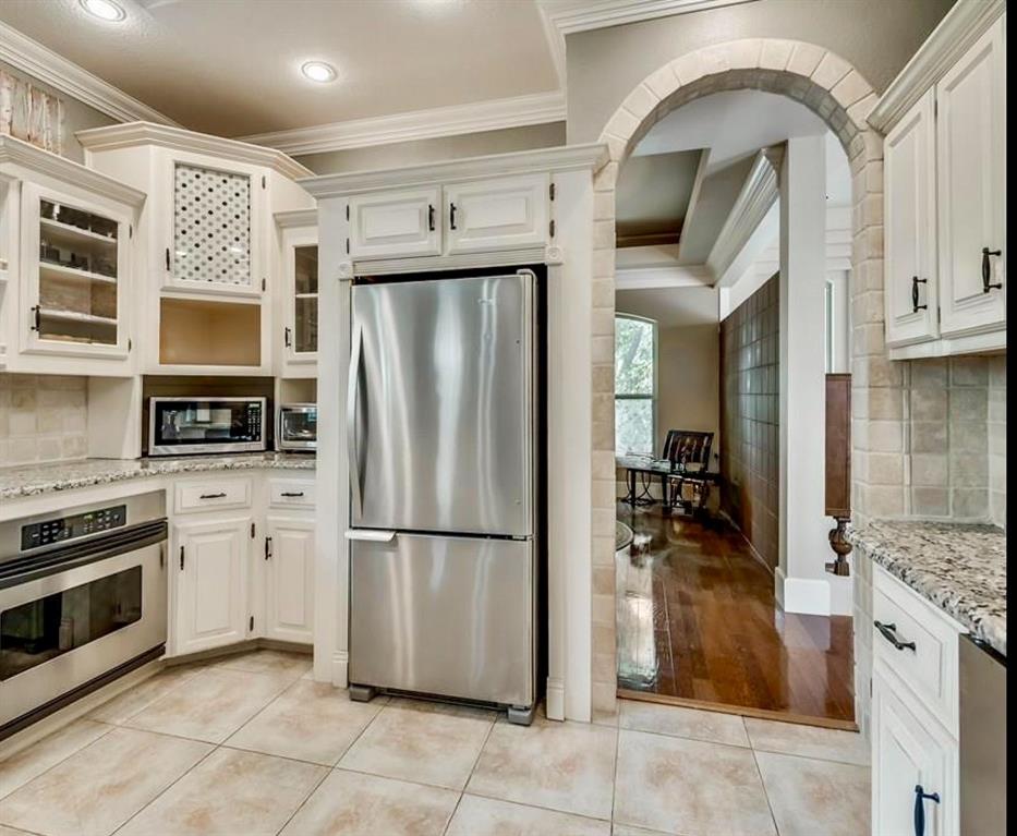 1450 Meandering Way Rockwall, TX 75087 - Photo 12 of 33 a kitchen with stainless steel appliances granite countertop a refrigerator a stove and a sink