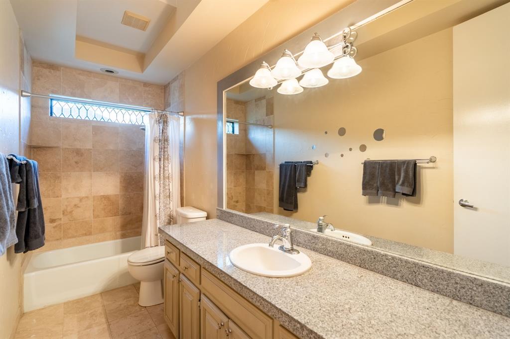 1450 Meandering Way Rockwall, TX 75087 - Photo 24 of 33 a bathroom with a granite countertop sink toilet and shower