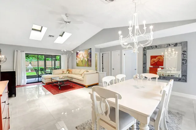 a living room with furniture a flat screen tv and a floor to ceiling window