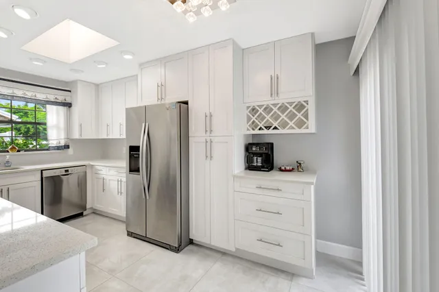a kitchen with white cabinets and refrigerator