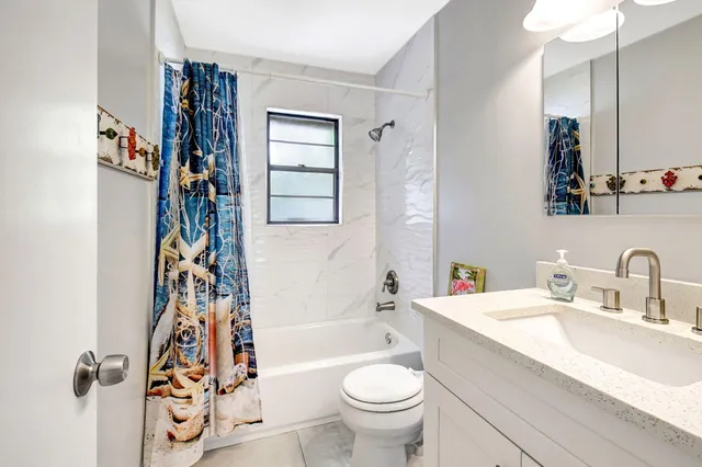 a bathroom with a toilet a sink a mirror and a bathtub