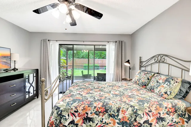 a bedroom with a large bed and a chandelier fan