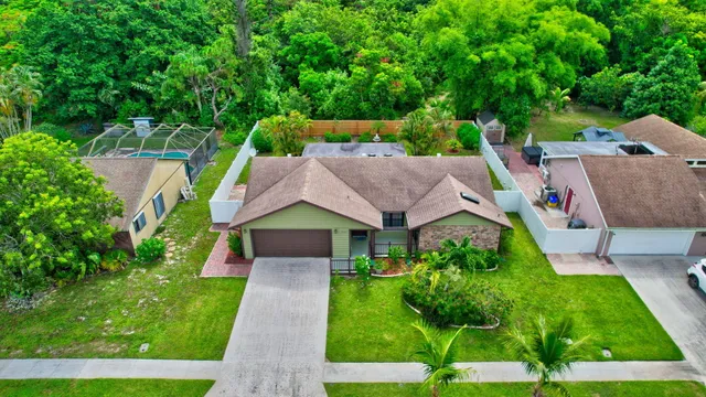 an aerial view of residential houses with outdoor space and trees