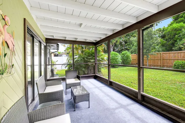a view of a porch with chairs and floor to ceiling window