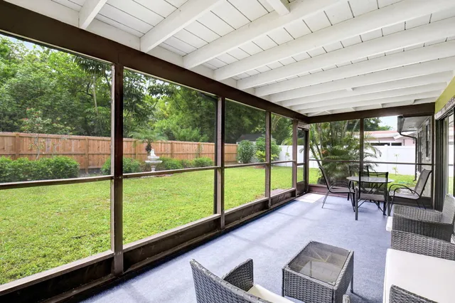 a living room with furniture floor to ceiling windows and a table