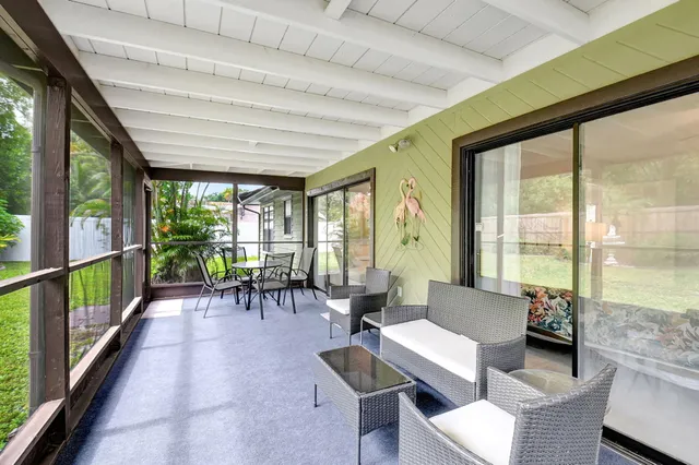 a view of a backyard with potted plants and large trees