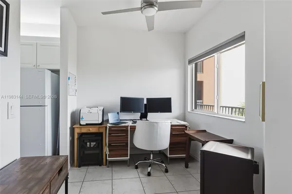 a view of a workspace with furniture and a window
