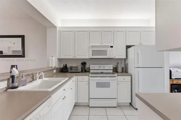a kitchen with white cabinets sink and white appliances