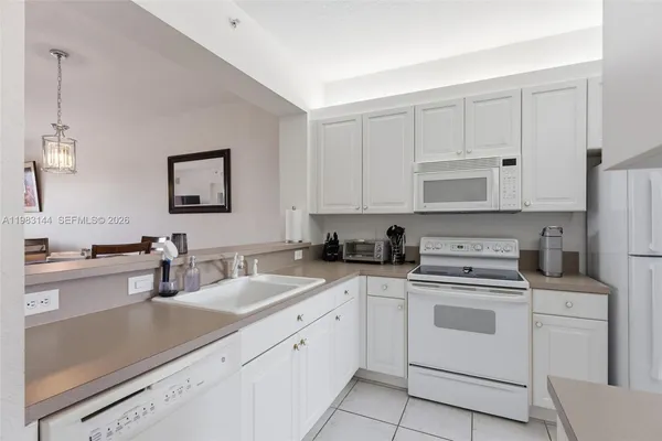 a kitchen with white cabinets sink and white appliances