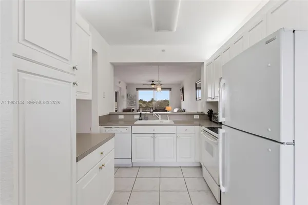 a kitchen with white cabinets and appliances