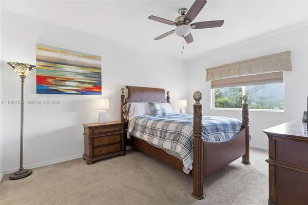 a bedroom with a bed chandelier and a window