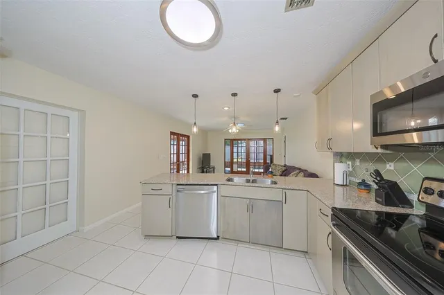 a kitchen with a refrigerator and chairs