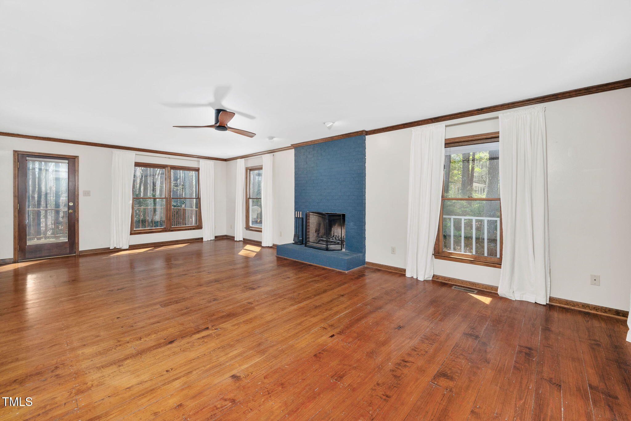 7917 Blaney Franks Road Apex, NC 27539 - Photo 4 of 50 a view of empty room with wooden floor and fireplace