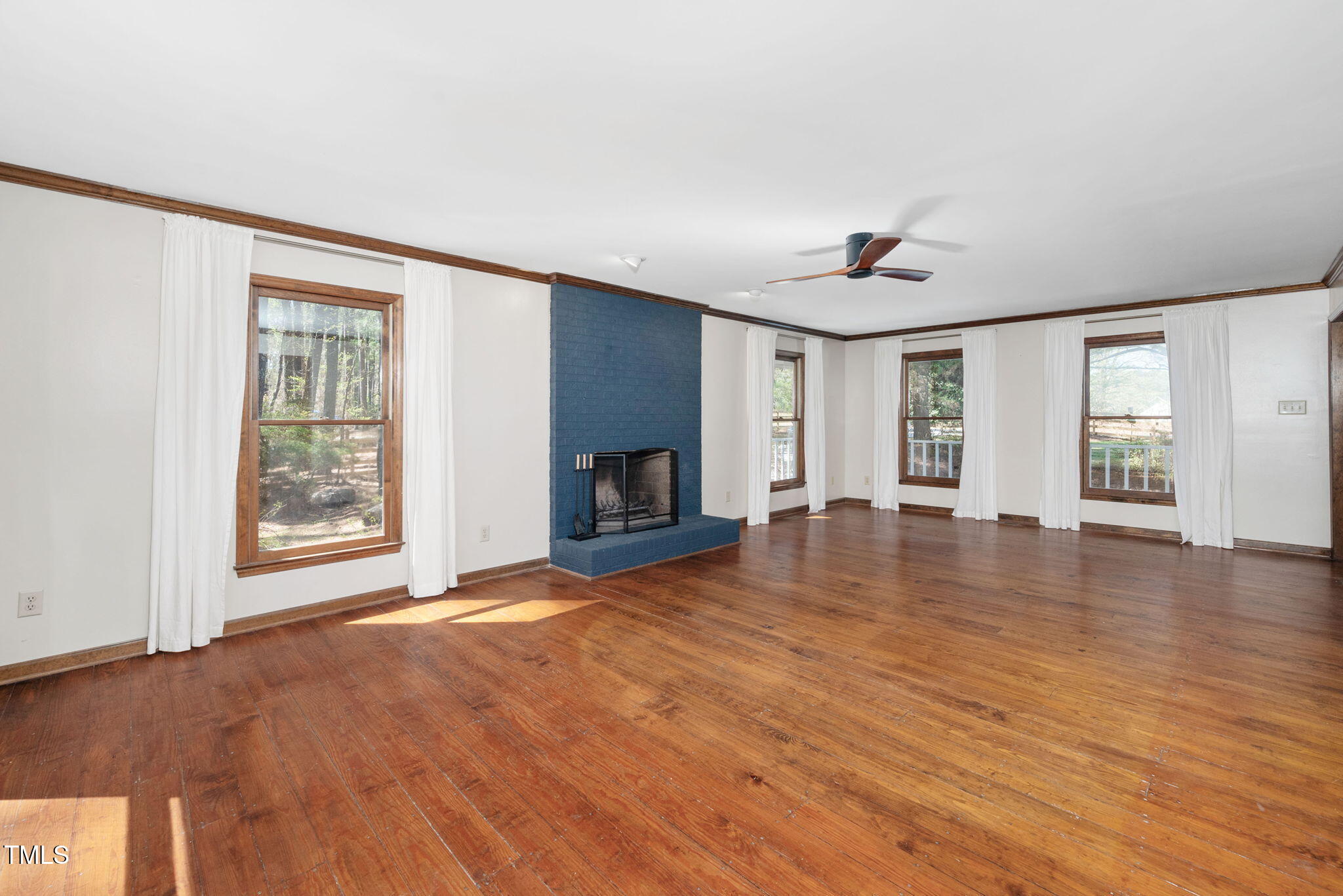 7917 Blaney Franks Road Apex, NC 27539 - Photo 7 of 50 a view of empty room with wooden floor and fireplace