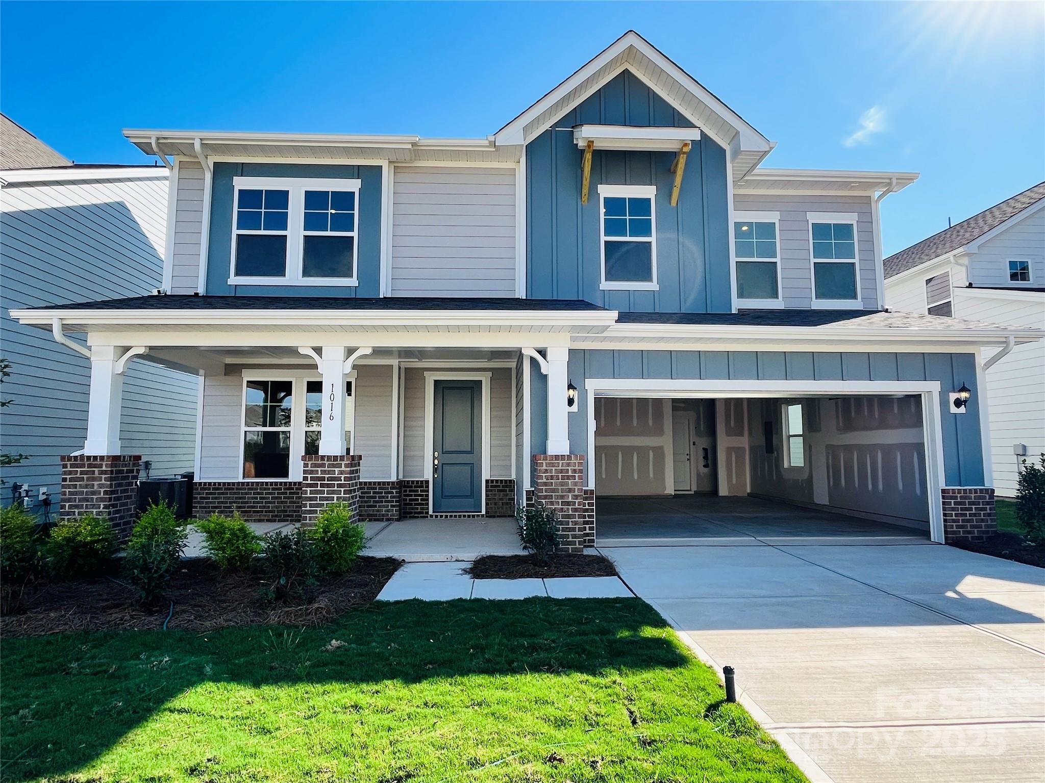 a front view of a house with yard and green space
