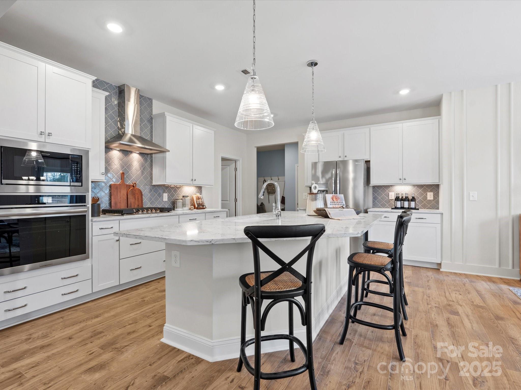 1016 Broken Spur Road Indian Trail, NC 28079 - Photo 4 of 19 a kitchen with stainless steel appliances a dining table chairs stove and white cabinets