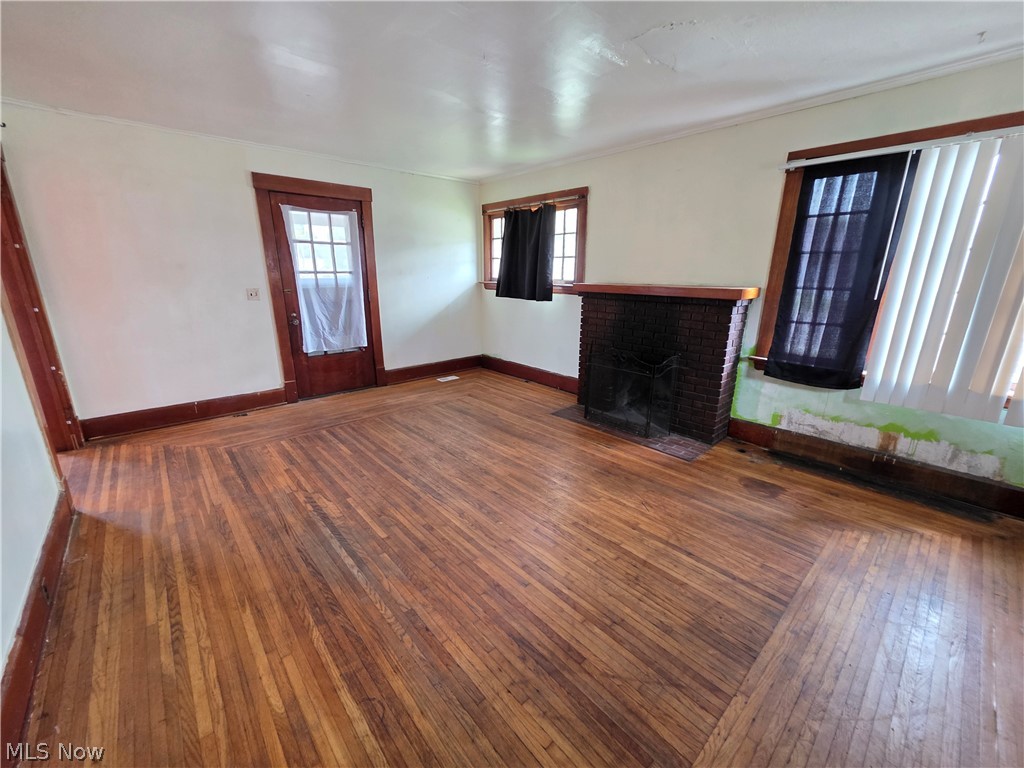 1801 West Prospect Road Ashtabula, OH 44004 - Photo 22 of 35 Wood-finish flooring, brick fireplace, and multiple windows