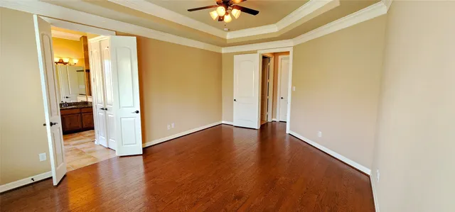a view of a livingroom with wooden floor and a ceiling fan
