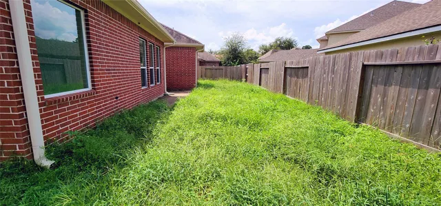 a view of a backyard with plants and wooden fence