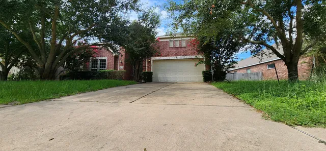 a front view of a house with yard and tree