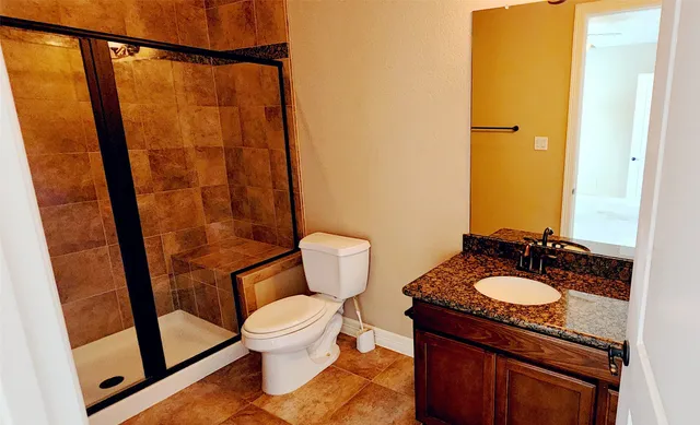 a bathroom with a granite countertop sink toilet and shower
