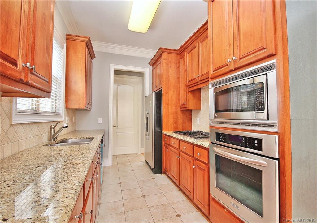 4608 McKee Road Charlotte, NC 28270 - Photo 11 of 32 a kitchen with granite countertop stainless steel appliances a stove sink and cabinets