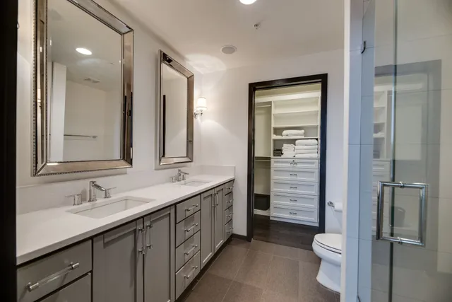 a bathroom with a double vanity sink toilet and shower