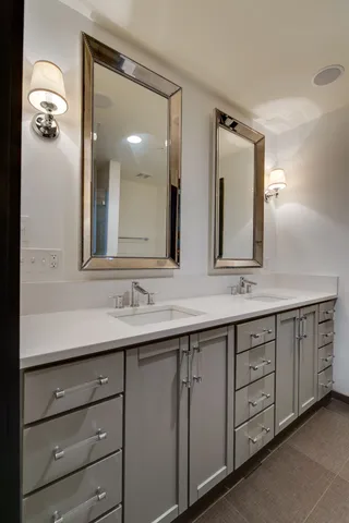 a bathroom with a granite countertop sink double vanity and a mirror
