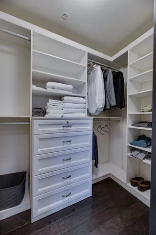 a view of walk in closet with clothes and shoes
