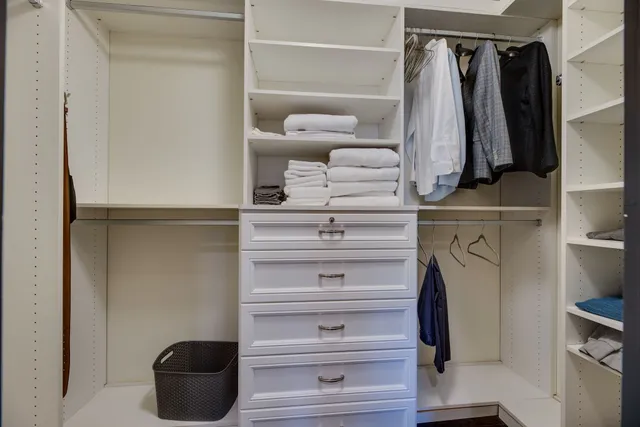 a view of walk in closet with clothes and shoes