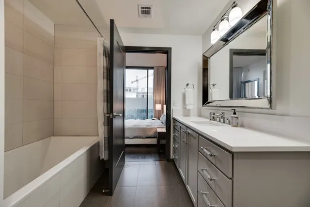 a bathroom with a tub sink and mirror