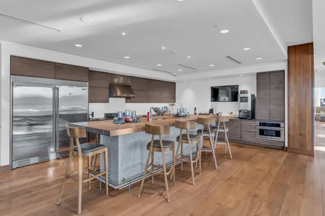 a view of a dining area with furniture wooden floor and a view of kitchen