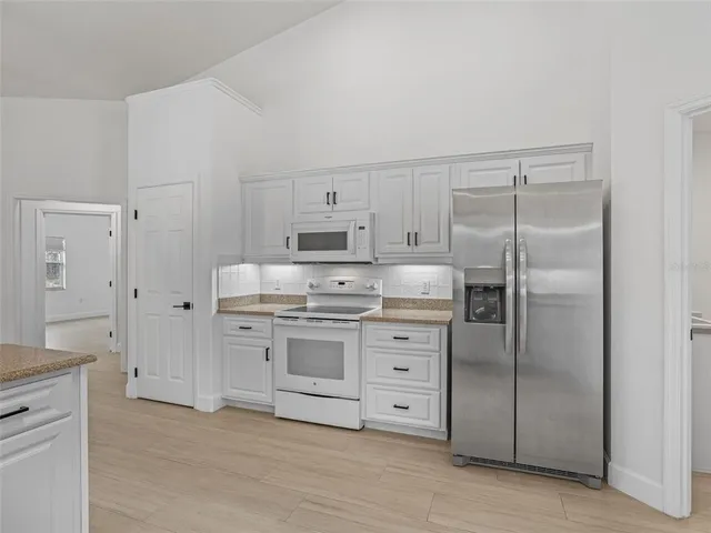 a large kitchen with kitchen island a sink stainless steel appliances and cabinets