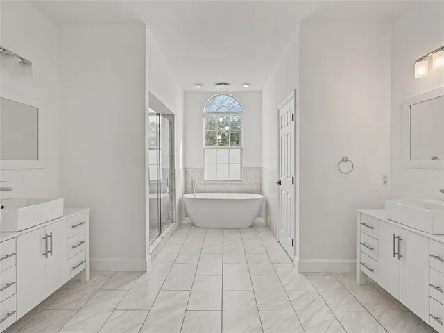 a spacious bathroom with a double vanity sink a toilet and a bathtub