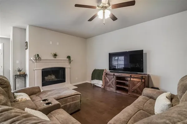 a living room with furniture a flat screen tv and a fireplace