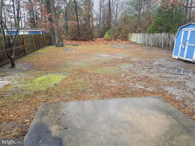 a view of back yard with wooden fence
