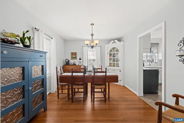 a kitchen with stainless steel appliances granite countertop a stove a sink dishwasher a microwave oven with white cabinets and a wooden floor