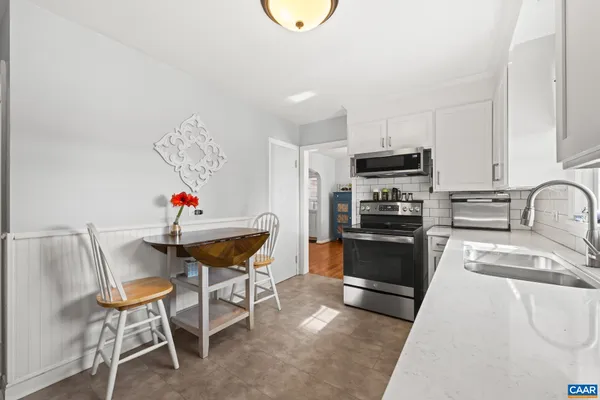 a kitchen that has a sink cabinets and stainless steel appliances