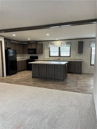 a large kitchen with kitchen island a sink stainless steel appliances and cabinets