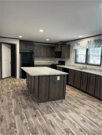 a large kitchen with wooden floors and stainless steel appliances