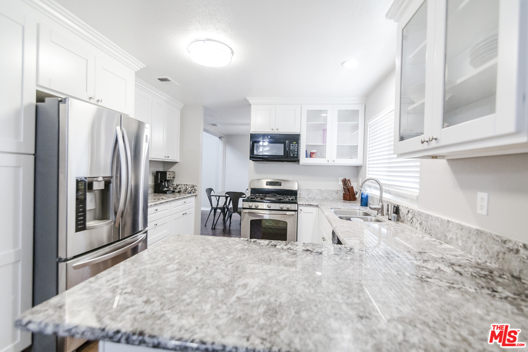 2985 North Chestnut Street Rialto, CA 92376 - Photo 11 of 30 a kitchen with stainless steel appliances granite countertop a refrigerator stove and sink
